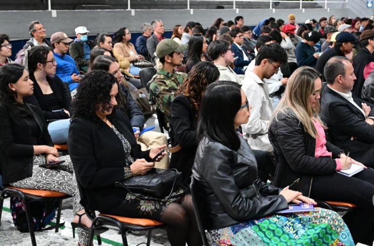 Fotografía de diferentes miembros de la comunidad universitaria en el auditorio multipropósito Simón Rodríguez, sede Calle 72.
