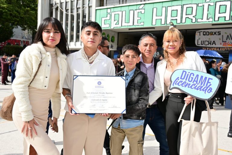 Foto familiar en la ceremonia de grados con el diploma y la paleta dígame licenciado